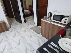 a kitchen with a white marble floor and a microwave at Cozy and lovely studio in Cairo