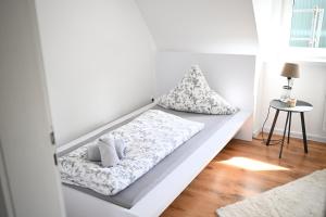 a white bed with pillows on it in a room at Ferienwohnung Siegen in Siegen