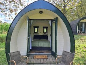 a bed in a dome tent with two chairs at B&B Uit de Kunst APPEL in Bingelrade
