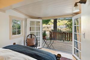 una camera da letto con un letto e un balcone di Luxury Riverview Cottage - walk to town & trails a Duncans Mills
