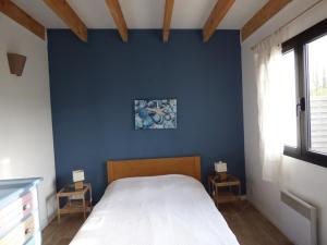 ein Schlafzimmer mit einer blauen Wand und einem Bett in der Unterkunft Maison à 100 m de la plage, port et commerces à pieds -Les gîtes de Rhuys in Sarzeau