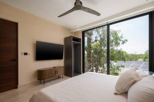 a bedroom with a large bed and a large window at Jungle Sky Loft in Tulum
