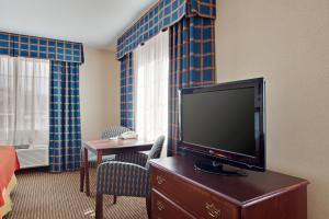 Holiday Inn Express & Suites Jackson, an IHG Hotel في جاكسون: غرفة في الفندق مع تلفزيون بشاشة مسطحة على خزانة ملابس