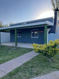 ein blaues Gebäude mit einem Baum davor in der Unterkunft Cabaña kaizen in San Rafael