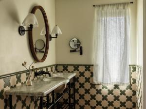 a bathroom with a sink and a mirror at La Playa Hotel in Carmel