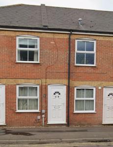 a brick building with white doors and windows at Walnut House - Modern 1 Bedroom Apartment very close to town by Shortstays4u in Kings Lynn