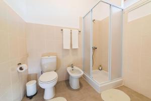 a white bathroom with a toilet and a shower at Guest House Genuíno in Horta