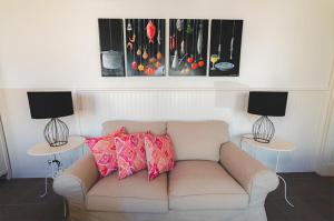 a living room with a couch and two tables with lamps at Guest House Genuíno in Horta +14 photos