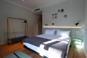a bedroom with a large bed and a clock on the wall at H Complutum in Alcalá de Henares