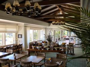 a dining room with tables and chairs and windows at La Playa Hotel in Carmel