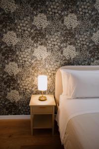 a bedroom with a bed and a table with a lamp at Alatea Porta Nuova 20 in Verona