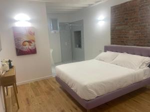 une chambre avec un lit et un mur de briques dans l'établissement Principessa Isabella, à Turin