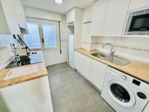 a white kitchen with a washing machine in it at La Ibiza del Pilar in Zaragoza
