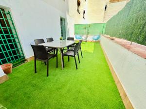 a table and chairs on a room with green grass at La Ibiza del Pilar in Zaragoza