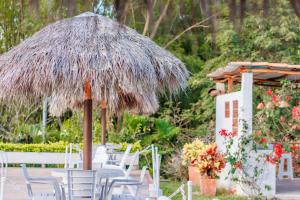 a table and chairs under a straw umbrella at CASA de CAMPO in Guaduas