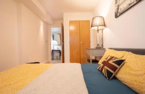 a bedroom with a bed and a table and a lamp at COSY RIVERVIEW-LONDON EXCEL CENTRE-O2 ARENA in London