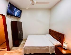 a bedroom with a bed and a flat screen tv at Habitación Céntrica en Iquitos - Casa Alemi 3 in Iquitos
