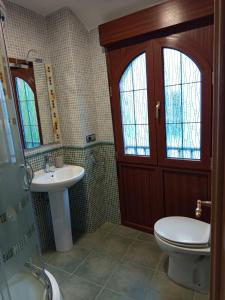 a bathroom with a toilet and a sink and a shower at Martínez Suite Burgos in Burgos