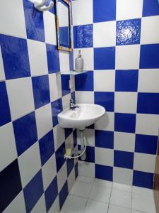 a bathroom with a sink and blue and white tiles at Hostal CasAlé Usaquén in Bogotá