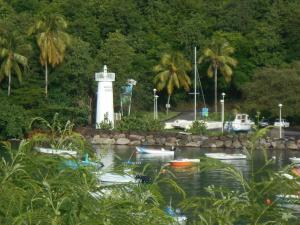 un faro en un cuerpo de agua con barcos en Appartement chez l habitant, en Vieux-Habitants