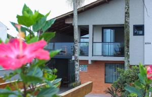a building with a pink flower in front of it at Casa de FRENTE para o Mar em Itapoá - SC in Itapoa