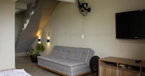 a living room with a couch and a flat screen tv at Casa de FRENTE para o Mar em Itapoá - SC in Itapoa +27 photos
