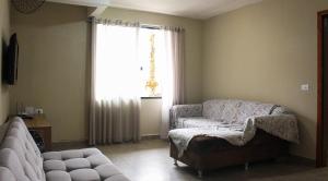 a living room with a couch and a chair and a window at Casa de FRENTE para o Mar em Itapoá - SC in Itapoa