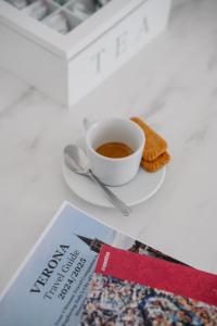 a cup of coffee sitting on a plate next to a newspaper at Alatea Porta Nuova 20 in Verona