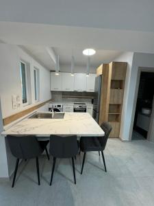 a kitchen with a large white table and chairs at Luxurious Modern Villa in Pefkohori