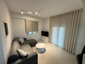 a living room with a couch and a television at Luxurious Modern Villa in Pefkohori