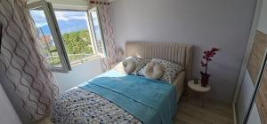 una piccola camera da letto con un letto e una finestra di Apartman Ana Maris a Fiume (Rijeka)