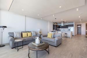 a living room with two couches and a table at Oceanfront Vibes Iconic Beachside Getaway in Puerto Peñasco