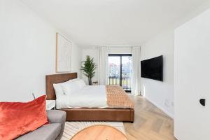 a white bedroom with a bed and a couch at Chic Minimalist City Retreat in Cape Town