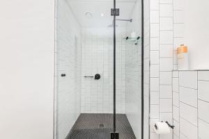 a shower with a glass door in a bathroom at Chic Minimalist City Retreat in Cape Town