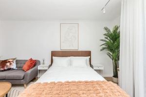 a bedroom with a bed and a couch at Chic Minimalist City Retreat in Cape Town