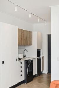 a kitchen with white walls and a black dishwasher at Chic Minimalist City Retreat in Cape Town +9 photos