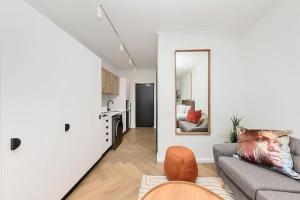 a living room with a couch and a kitchen at Chic Minimalist City Retreat in Cape Town