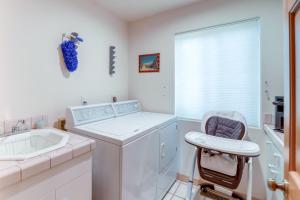 a white laundry room with a washing machine and a chair at Hot Tub, Fire Pit and Deck Chic Arizona Retreat in Pine +18 photos