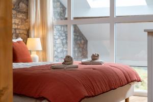 a bedroom with a bed with two stuffed animals on it at Le Bain de Diane - Maisons Paladins in Sougné-Remouchamps