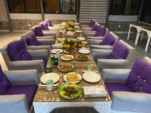 a long table with purple chairs and plates of food at فندق اربد بلازا in Irbid