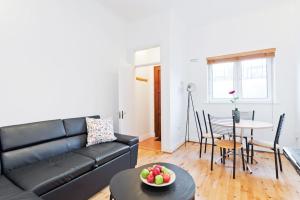 un salon avec un canapé noir et une table dans l'établissement Blarney Apt 1BR Sleeps 4, à Dublin