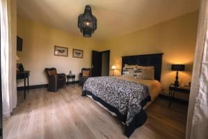 a bedroom with a bed and a table and chairs at Domaine de Neuvon in Plombières-lès-Dijon
