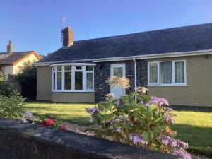 a house with a garden in front of it at Snowdonia coastal getaway ideal for groups up to 6 in Llwyngwril