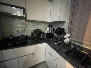 Una cocina con gabinetes blancos y una encimera negra. en Luxury Budgethomes Bukoto, en Kampala