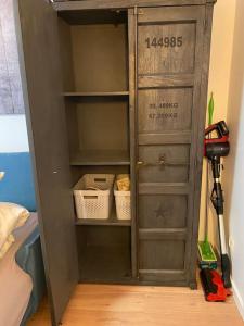 ein grauer Schrank mit Regalen und Werkzeugen in einem Raum in der Unterkunft Studio-Apartment Weimar in Weimar