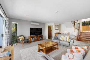 a living room with a couch and a table at Belfast Retreat - Views and Spa Pool in Queenstown