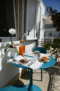 Ein blauer Tisch mit Tellern voller Essen auf einem Balkon in der Unterkunft Flowing House in Brindisi