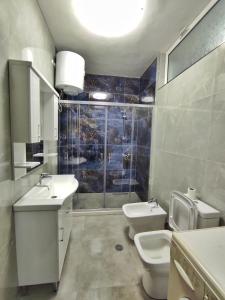 a bathroom with two sinks and a toilet and a shower at Noor Apartment in Durrës +7 photos
