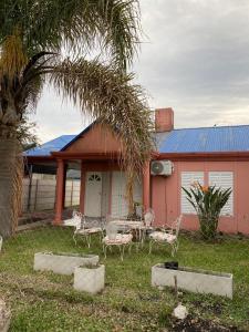una casa con una palmera, una mesa y sillas en Alquiler Villa Elisa, en Villa Elisa 1 foto más