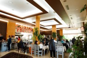 a dining room with people sitting at tables in a restaurant at Autogrill Hotel restaurant & Camping in Gjirokastër